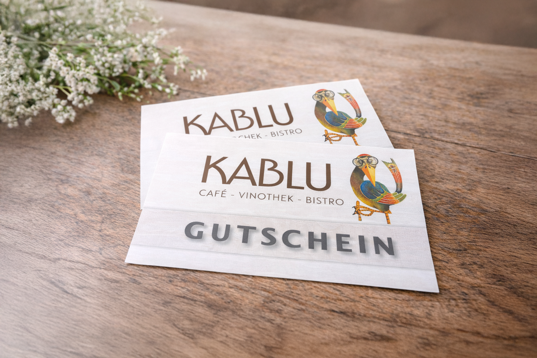 kablu_gutscheine Kablu Gutscheine auf Tisch liegend mit Blumen als Dekoration